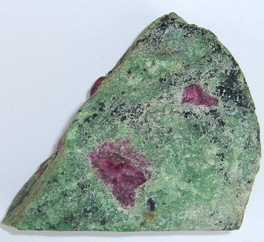 Anyolite from the Merkerstein area of Northern Tanganyika. Apple green zoisite, red ruby corundum and very dark green hornblende. The cut side of the specimen is 11cm long.